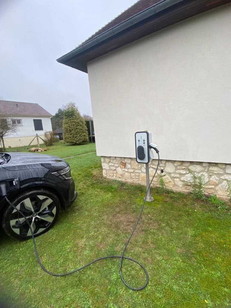 Borne sur pied pour recharge de voiture électrique dans un jardin.